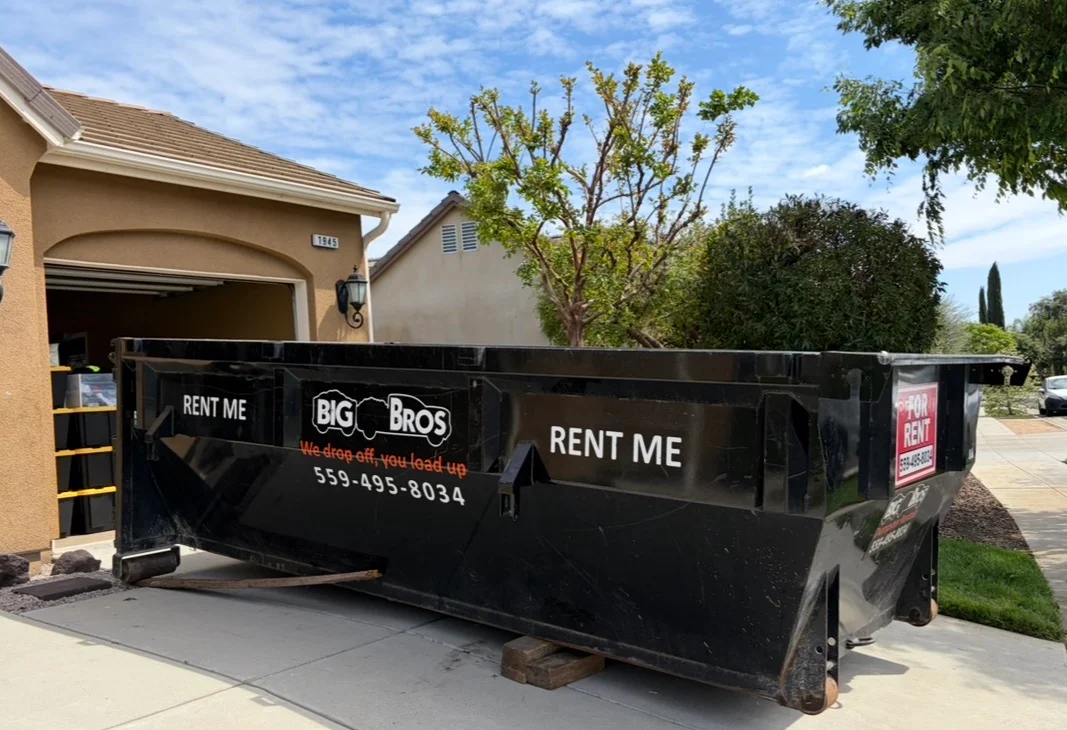 Big Bros dumpster on a driveway with the We drop off, you load up tagline