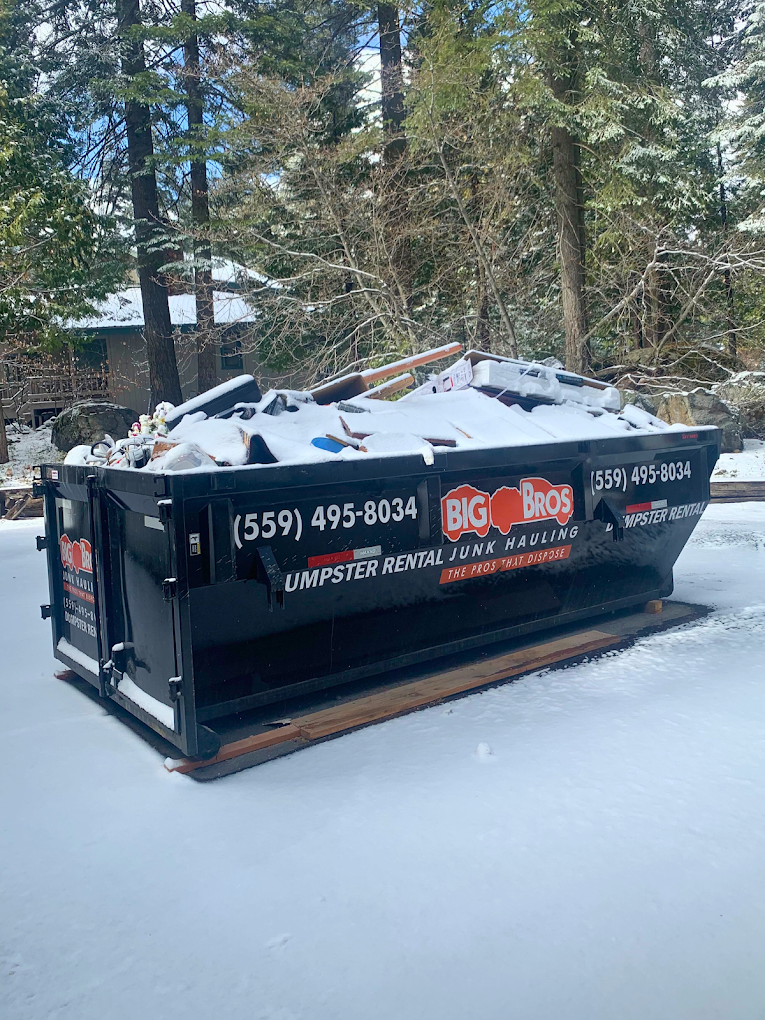 A Big Bros dumpster filled with debris, loaded and ready to be hauled out